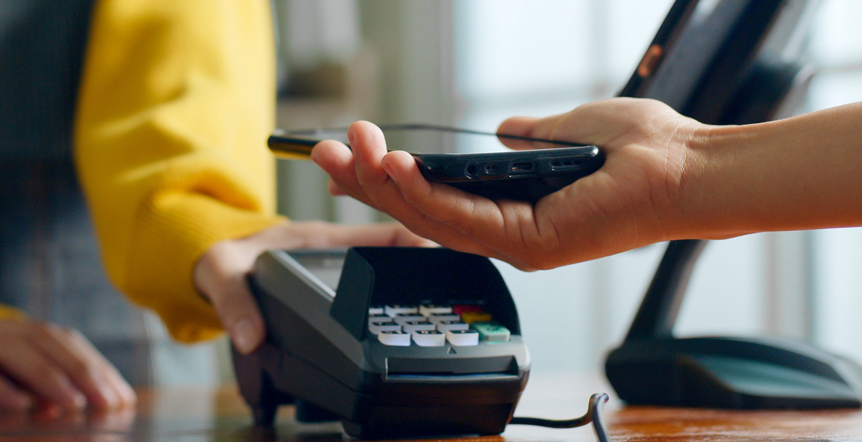 A person paying fora purchase with their phone