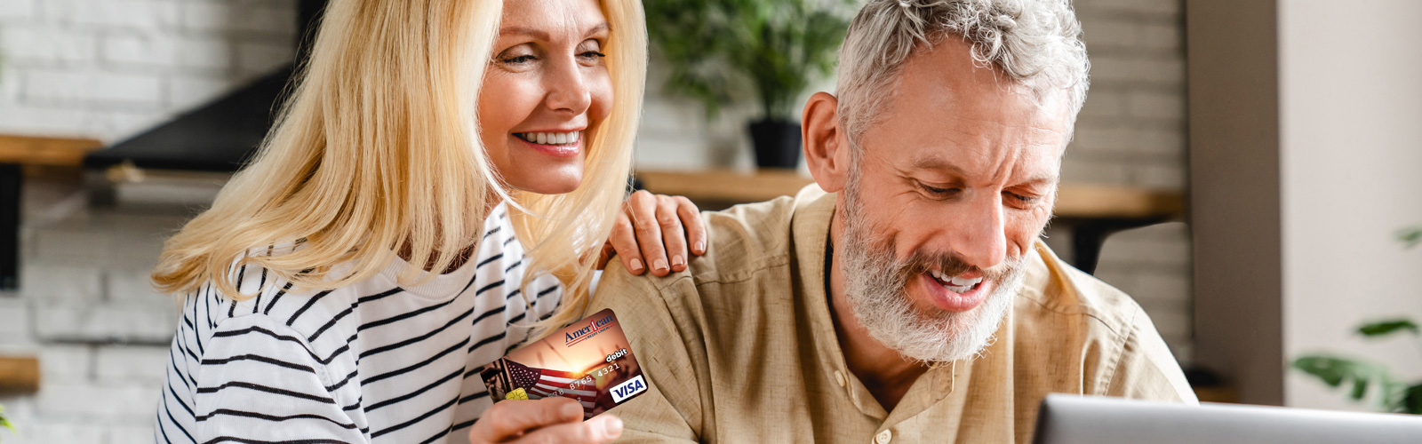 Couple smiling looking at a computer