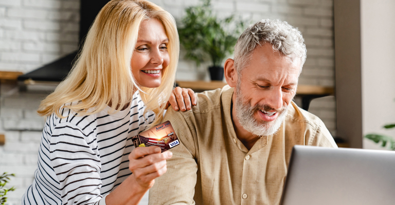 Couple smiling looking at a computer