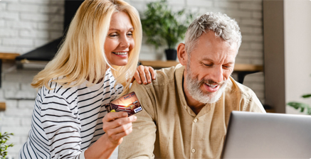 Couple smiling looking at a computer