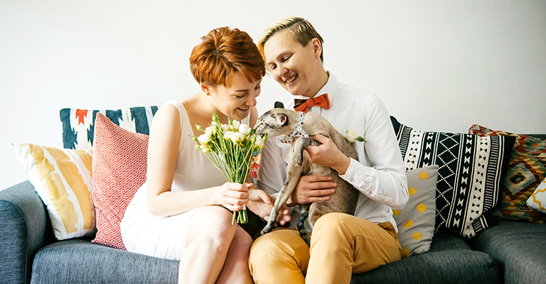 Couple holding cat on a couch