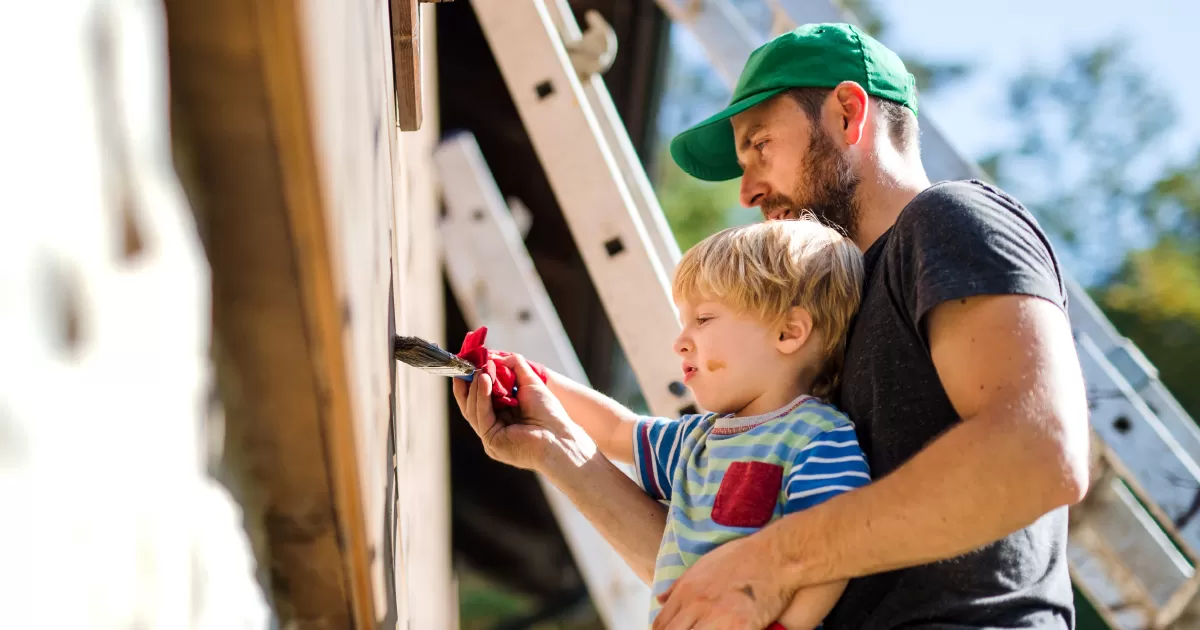 Father and son painting a house